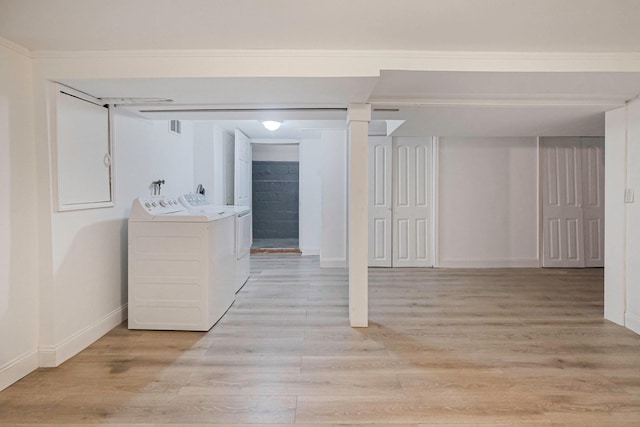 washroom featuring light wood-style floors, washing machine and dryer, laundry area, and baseboards