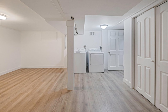 laundry area with washer and clothes dryer, light wood finished floors, visible vents, laundry area, and baseboards