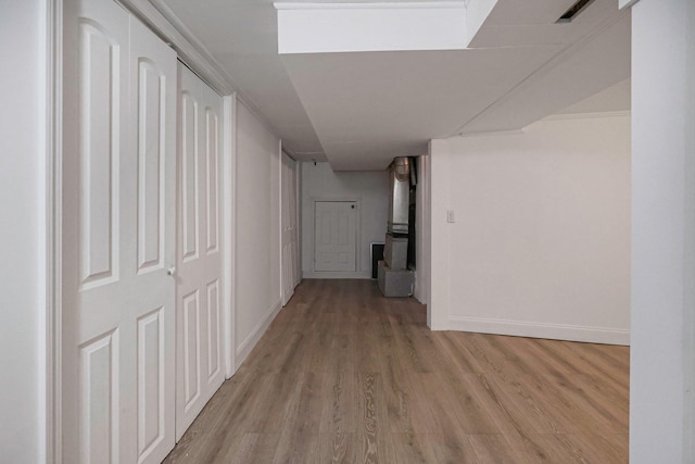 hall featuring light wood-type flooring and baseboards