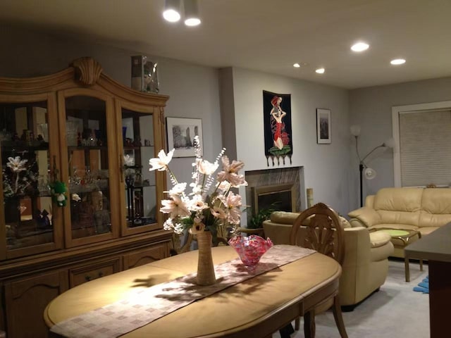 dining room with light carpet, a fireplace, and recessed lighting