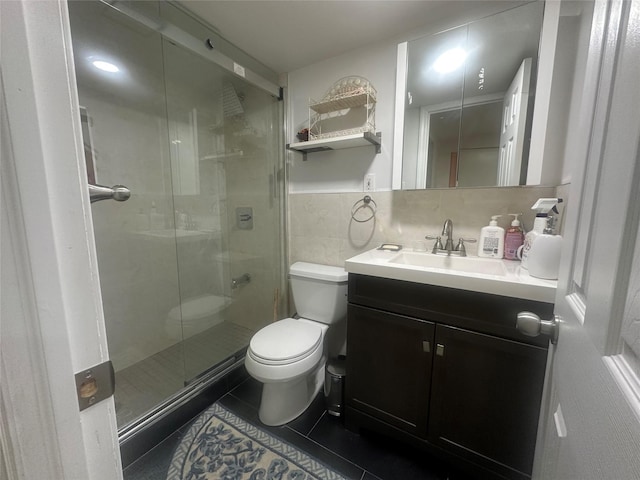 bathroom featuring tile patterned flooring, toilet, vanity, tile walls, and a shower stall