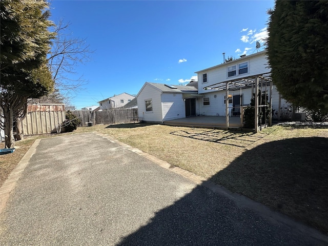 rear view of property with a yard, a fenced backyard, and a patio