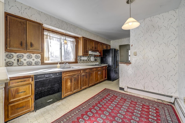 kitchen with a sink, wallpapered walls, black appliances, under cabinet range hood, and light countertops