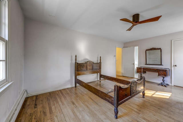 bedroom with a ceiling fan, baseboards, light wood-style flooring, and a baseboard radiator