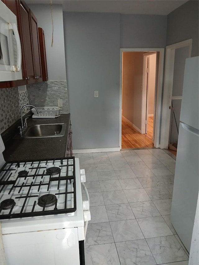 kitchen featuring white appliances, marble finish floor, decorative backsplash, and a sink