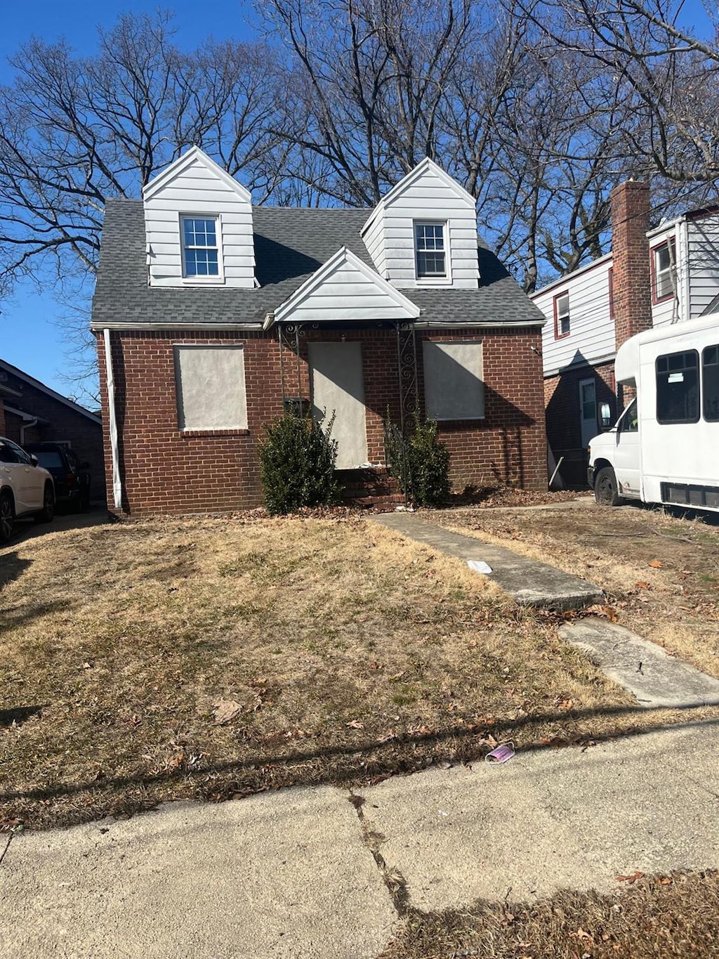 view of front of property featuring roof with shingles and brick siding