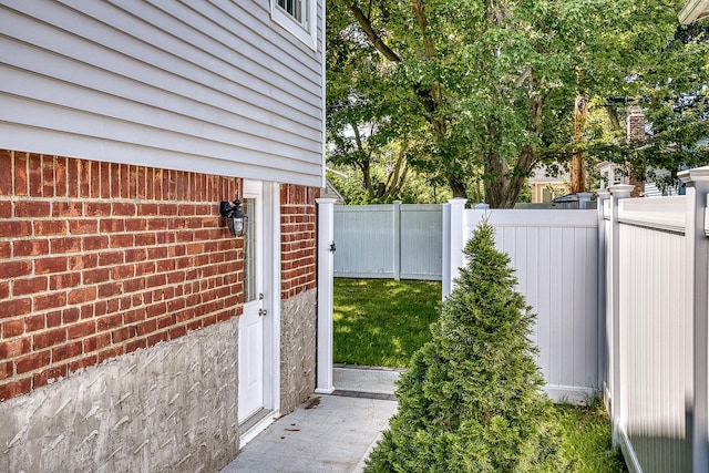 exterior space with fence and brick siding