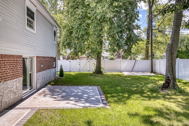 view of yard with a gate, a fenced backyard, and a patio