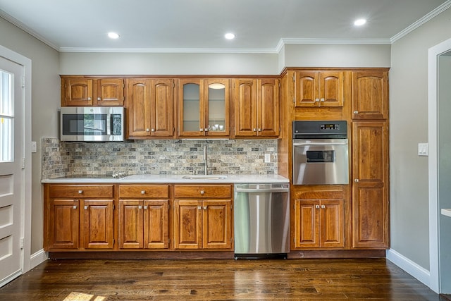 kitchen featuring brown cabinets, stainless steel appliances, a sink, and light countertops