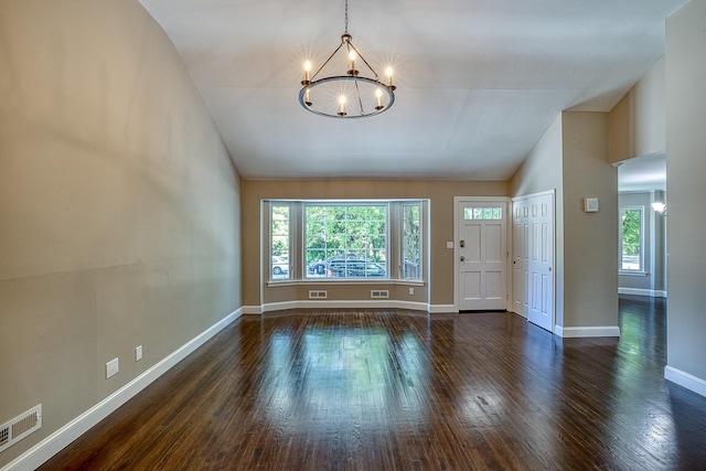 foyer entrance featuring dark wood-style floors, an inviting chandelier, visible vents, and baseboards