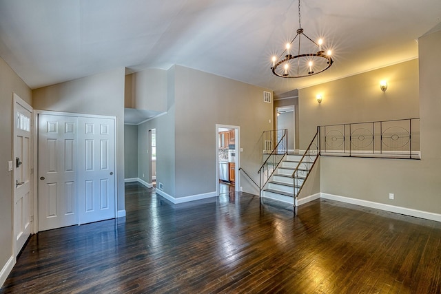 entryway with baseboards, lofted ceiling, stairway, wood finished floors, and a chandelier