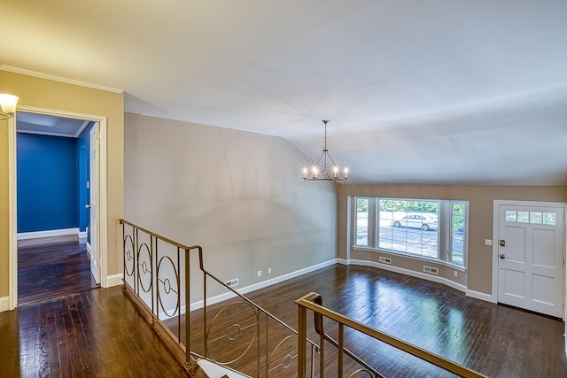 entrance foyer with vaulted ceiling, baseboards, wood finished floors, and an inviting chandelier