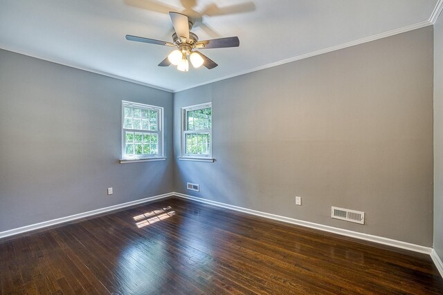 spare room with baseboards, visible vents, dark wood finished floors, and ornamental molding