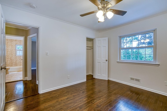 unfurnished bedroom featuring multiple windows, wood finished floors, visible vents, and crown molding