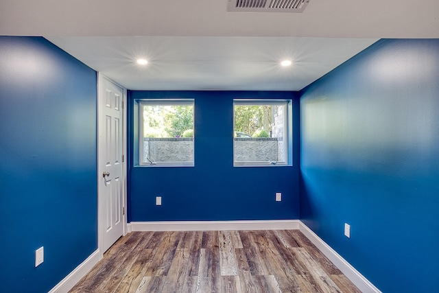 unfurnished room with baseboards, visible vents, wood finished floors, and recessed lighting