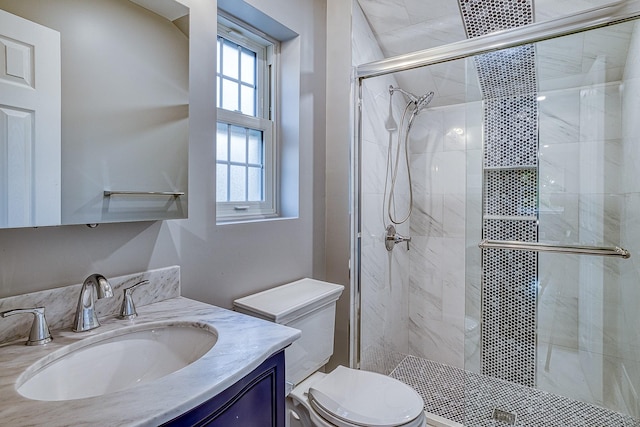 bathroom with vanity, a shower stall, and toilet