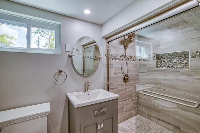 bathroom featuring vanity, a tile shower, and toilet