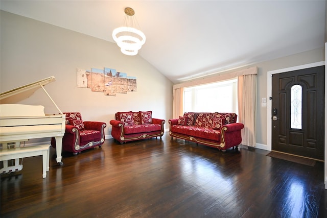 living area featuring a notable chandelier, vaulted ceiling, baseboards, and wood finished floors