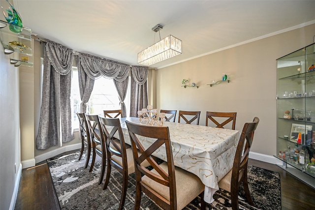 dining area featuring baseboards, wood finished floors, and crown molding