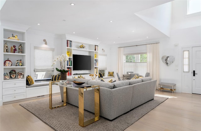 living area featuring ornamental molding, light wood finished floors, visible vents, and recessed lighting