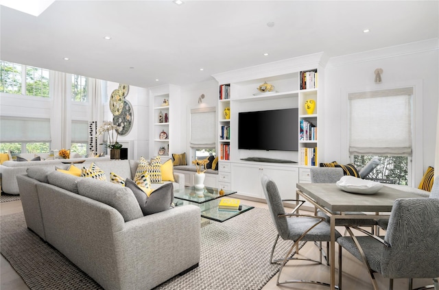 living room with built in features, recessed lighting, crown molding, and plenty of natural light