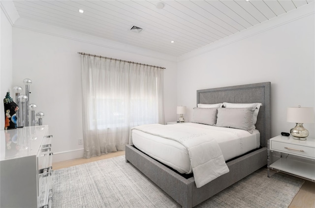 bedroom with wood ceiling, ornamental molding, wood finished floors, and visible vents