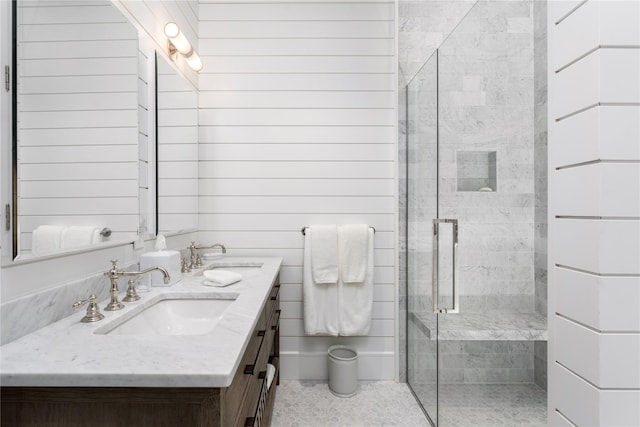 bathroom featuring a stall shower, a sink, and double vanity