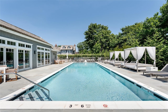 community pool with french doors, a patio, and fence