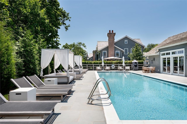 view of pool with a fenced in pool, fence, a patio, and french doors