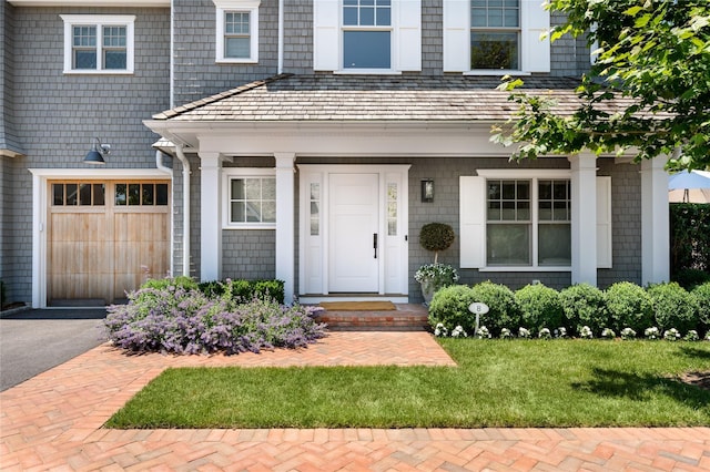 property entrance featuring a garage and aphalt driveway