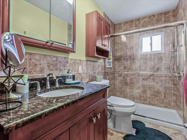 bathroom featuring toilet, vanity, a shower stall, and tile walls