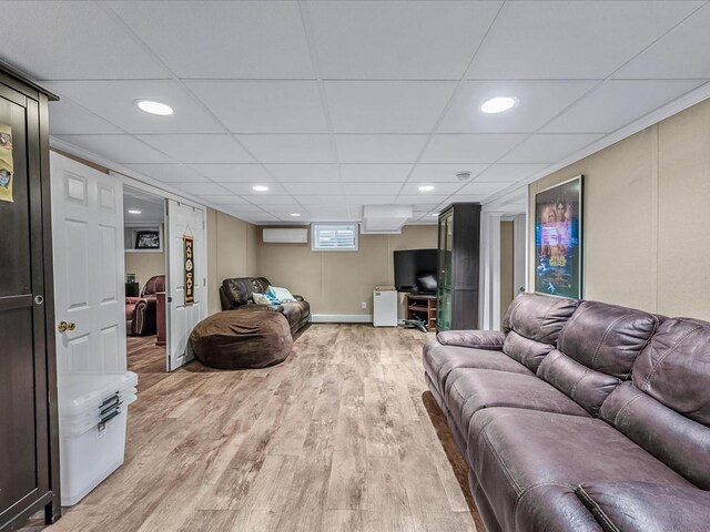 living area featuring light wood-style floors, a drop ceiling, and recessed lighting