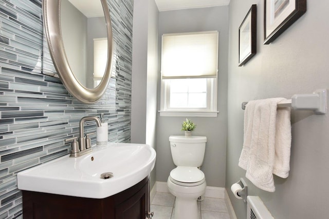 half bath featuring tile patterned flooring, baseboards, vanity, and toilet