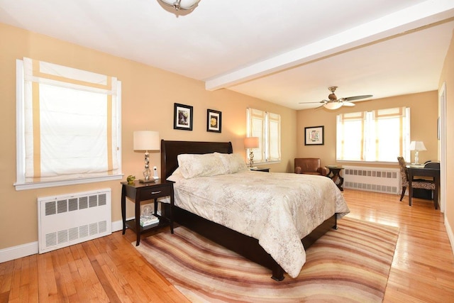 bedroom with beamed ceiling, wood-type flooring, and radiator