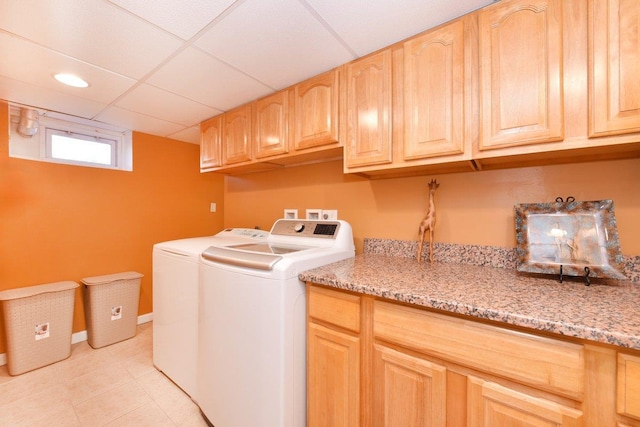 laundry area with cabinet space, washer and clothes dryer, baseboards, and light tile patterned floors