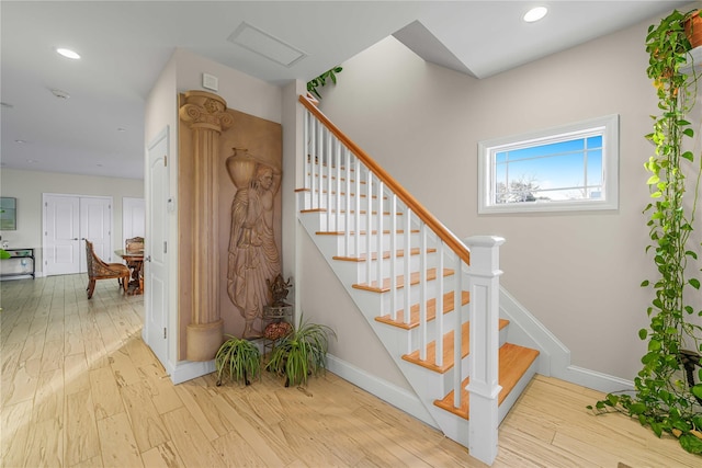 staircase featuring recessed lighting, visible vents, baseboards, and wood finished floors