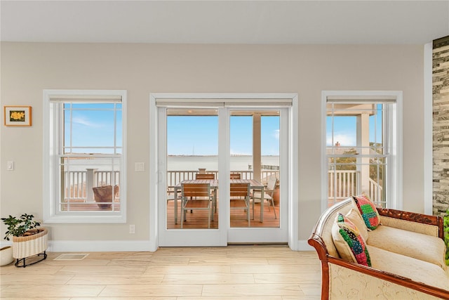 doorway to outside featuring a wealth of natural light, baseboards, and wood finished floors