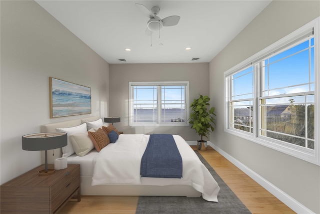 bedroom featuring visible vents, multiple windows, and light wood-style flooring