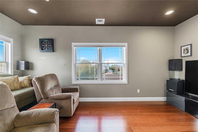 living room with recessed lighting, wood finished floors, visible vents, and baseboards