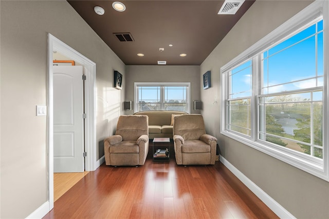 sitting room with recessed lighting, visible vents, baseboards, and wood finished floors