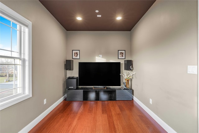 living area with baseboards, wood finished floors, and recessed lighting