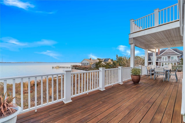 wooden deck featuring a water view and outdoor dining space