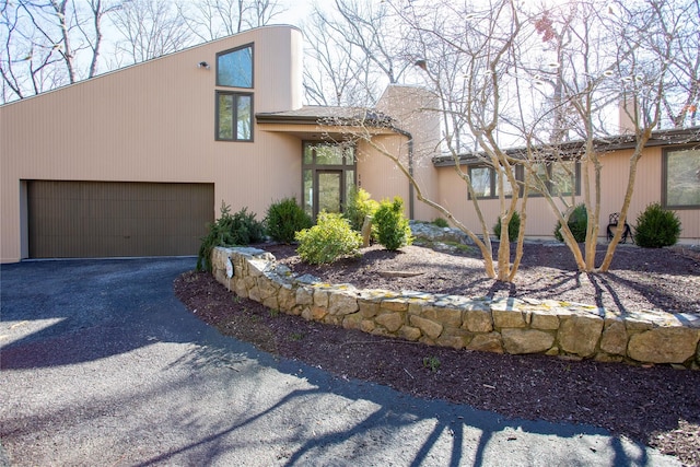 view of front of home featuring aphalt driveway and a garage