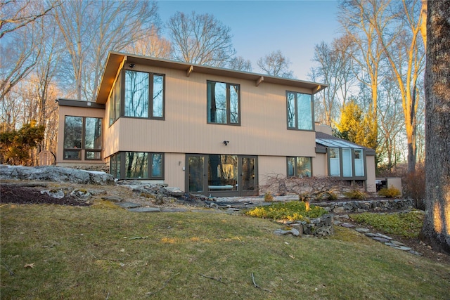 rear view of house featuring a lawn