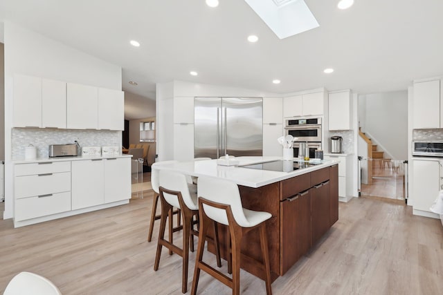 kitchen featuring a skylight, appliances with stainless steel finishes, and modern cabinets