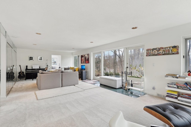 living area featuring visible vents and light carpet