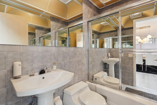 full bathroom featuring tile walls, toilet, tasteful backsplash, and a sink