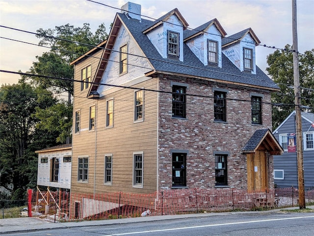 view of front of property featuring roof with shingles and brick siding