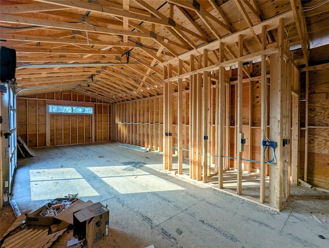 miscellaneous room with a garage and vaulted ceiling