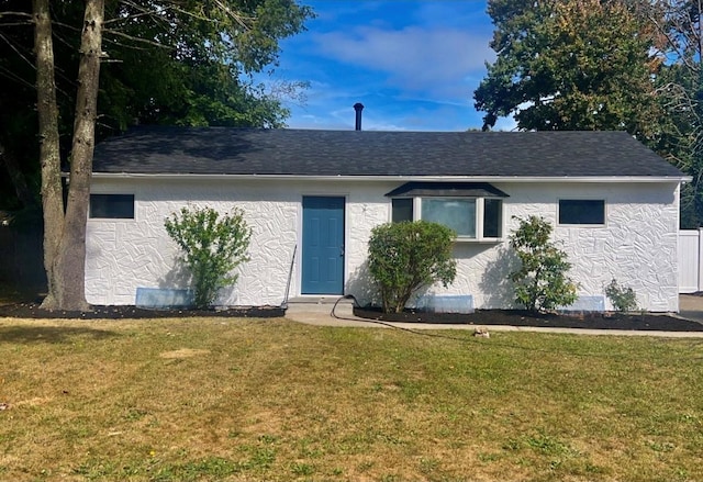 single story home featuring roof with shingles, a front yard, and stucco siding